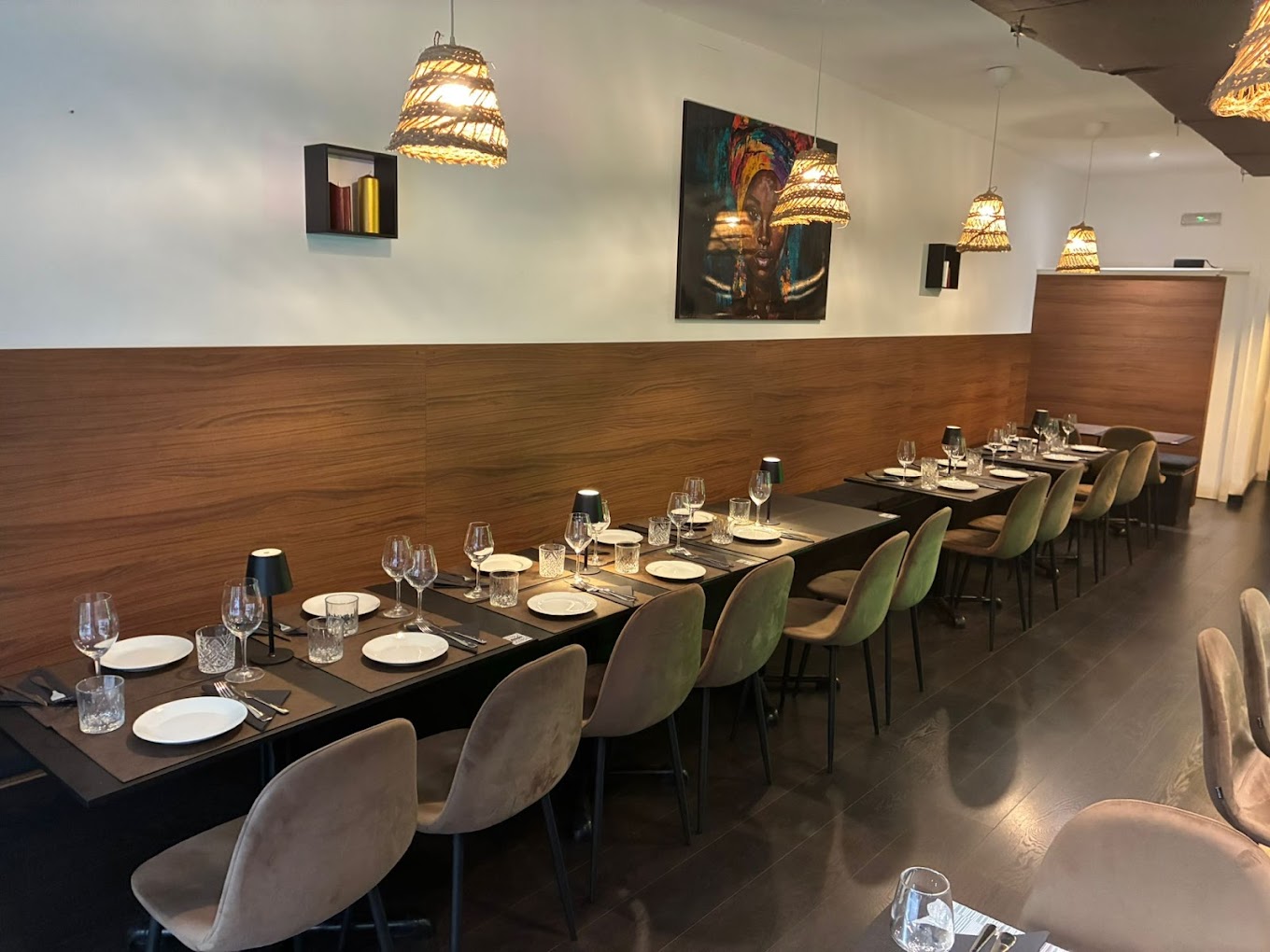 Interior de Restaurante Arantxa, mesas vestidas con velvet sage y paneles de madera nogal
