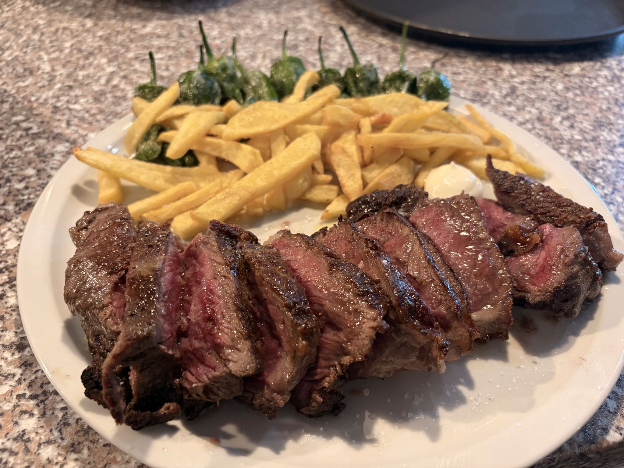 Entrecot trinchado con patatas y pimientos de padrón
